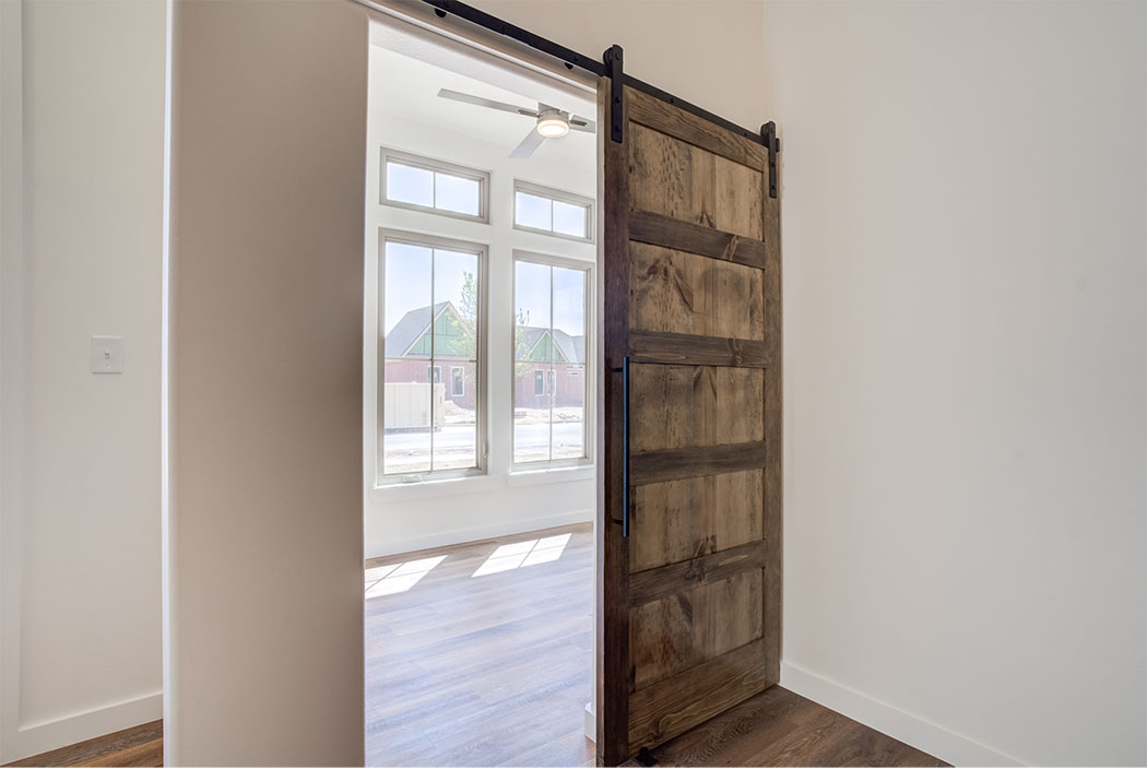 Spacious home office with specialty barn doors and plenty of windows.