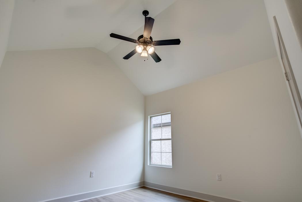 Spacious bedroom with ceiling fan in new home for sale in Lubbock, Texas.