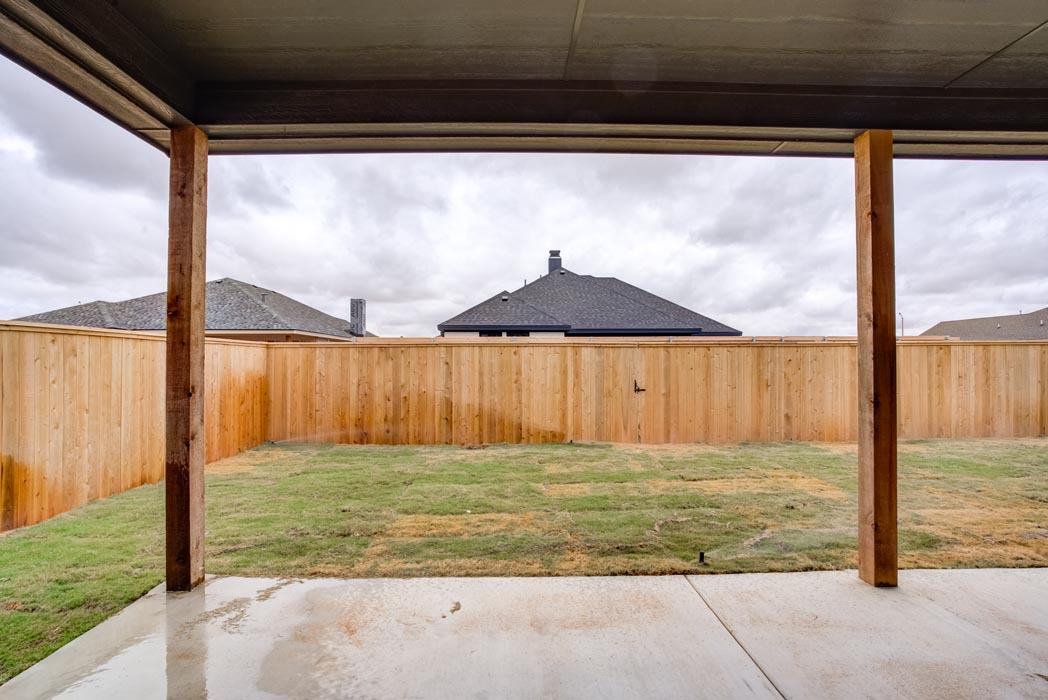Covered patio and spacious backyard area of new Lubbock home.