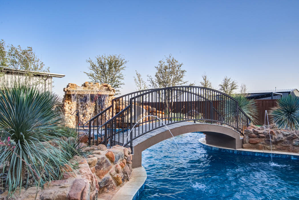 Custom swimming pool with bridge, in amazing outdoor space of custom home near Lubbock.