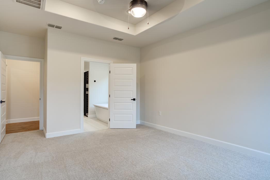 Guest bedroom in new Lubbock home, which features expansive space and a closet