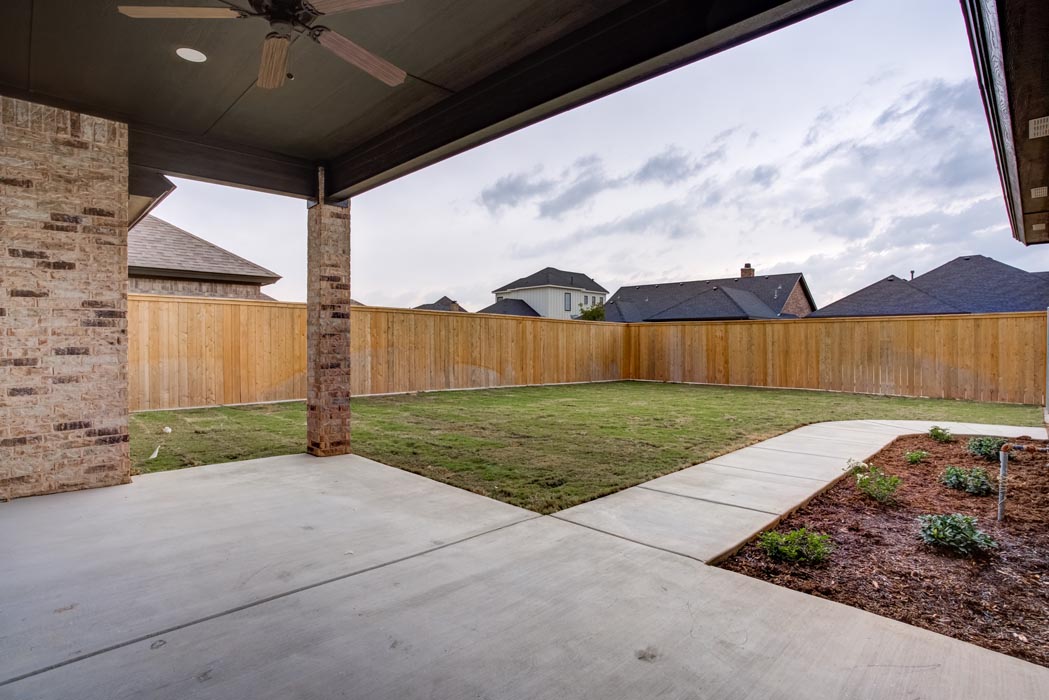 View of back patio and spacious backyard of new Lubbock, Texas home.