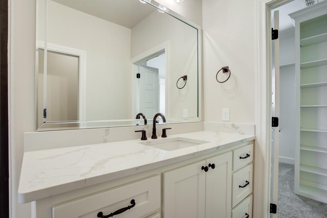 Vanity and cabinets in spacious master bathroom of new home for sale in Lubbock.