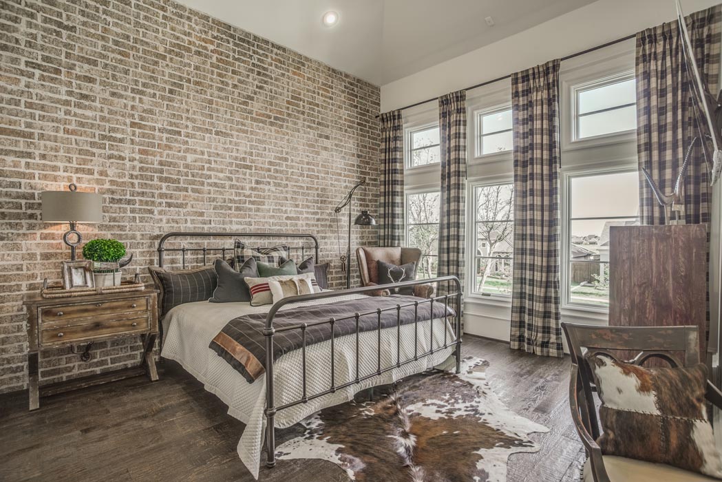 Bedroom with brick accent wall in custom home.